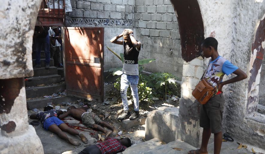 People look at the the bodies of three persons shot dead after an overnight shooting in the Pétion Ville neighborhood of Port-au-Prince, Haiti, Monday, April 1, 2024.(AP Photo/Odelyn Joseph)