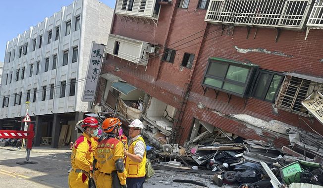 In this photo released by the National Fire Agency, members of a search and rescue team prepare outside a leaning building in the aftermath of an earthquake in Hualien, eastern Taiwan on Wednesday, April 3, 2024. Taiwan&#x27;s strongest earthquake in a quarter century rocked the island during the morning rush Wednesday, damaging buildings and creating a tsunami that washed ashore on southern Japanese islands. (National Fire Agency via AP)