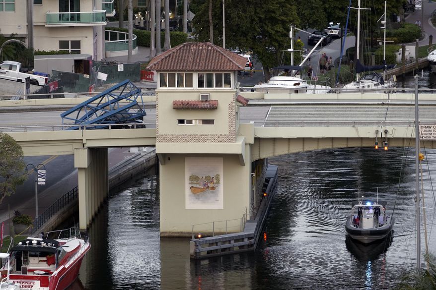 A construction worker was killed and two people were taken to the hospital after a portion of a crane dropped onto the Southeast Third Avenue bridge over the New River in downtown Fort Lauderdale, Fla., Thursday, April 4, 2024. (AP Photo/Daniel Kozin)