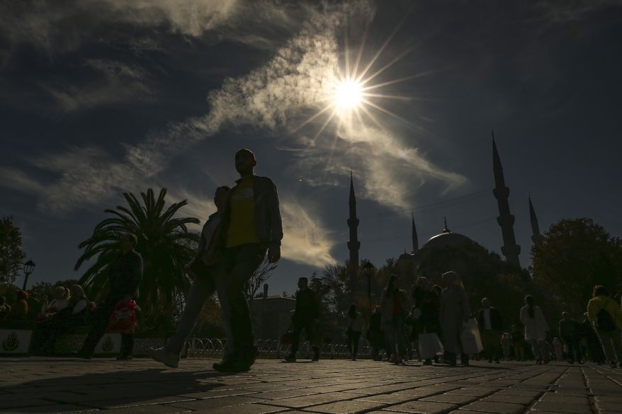 Pedestrians walk near Sultan Ahmed mosque during a partial solar eclipse in Istanbul, Turkey, Tuesday, Oct. 25, 2022. Throughout history, solar eclipses have had profound impact on adherents of various religions around the world. They were viewed as messages from God or spiritual forces, inducing emotions ranging from dread to wonder. (AP Photo/Emrah Gurel) **FILE**