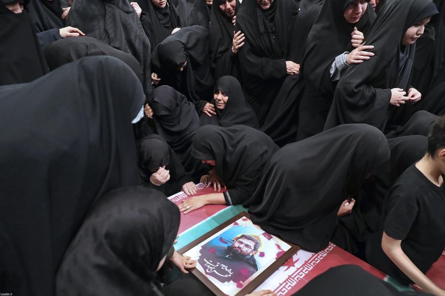 In this photo released by an official website of the office of the Iranian supreme leader, families mourn over the flag-draped coffins of the Iranian Revolutionary Guards members who were killed in an airstrike in Syria on Monday widely blamed on Israel, in Tehran, Iran, Thursday, April 4, 2024. (Office of the Iranian Supreme Leader via AP)