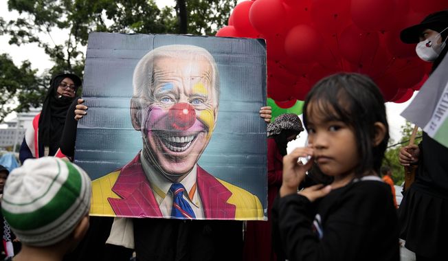 Protesters display a poster depicting U.S. President Joe Biden as a clown during an Al-Quds (Jerusalem) Day rally outside the U.S. Embassy in Jakarta, Indonesia, Friday, April 5, 2024. Al-Quds Day which was declared by the late Iranian spiritual leader Ayatollah Ruhollah Khomeini in 1979 as a day of struggle against Israel and to demonstrate the importance of Jerusalem to Muslims is observed every last Friday of the Muslim holy month of Ramadan. (AP Photo/Dita Alangkara)