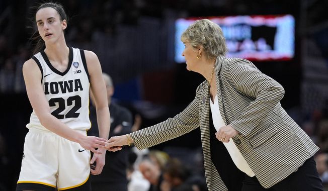 Iowa guard Caitlin Clark (22) reacts with head coach Lisa Bluder during the second half of a Final Four college basketball game against UConn in the women&#x27;s NCAA Tournament, Friday, April 5, 2024, in Cleveland. (AP Photo/Morry Gash)