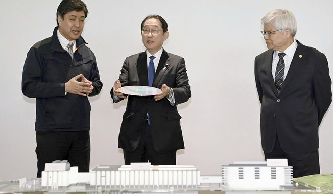 Japanese Prime Minister Fumio Kishida, center, is briefed as he visits a plant of the Taiwan Semiconductor Manufacturing Co. in Kikuyo town, Kumamoto prefecture, southern Japan Saturday, April 6, 2024. At right is Taiwan Semiconductor Manufacturing Company CEO C.C. Wei. (Japan Pool/Kyodo News via AP)