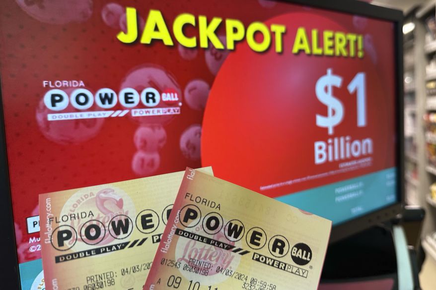Powerball tickets are shown in front of a screen displaying the estimated jackpot, Wednesday, April 3, 2024, in Surfside, Fla. Lottery players will have another shot Saturday night, April 6, 2024, at a Powerball jackpot that has grown to an estimated $1.3 billion after more than three months without a winner. (AP Photo/Wilfredo Lee, File)