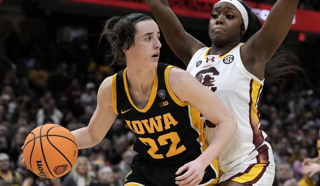 Iowa guard Caitlin Clark (22) drives around South Carolina guard Raven Johnson (25) during the second half of the Final Four college basketball championship game in the women&#x27;s NCAA Tournament, Sunday, April 7, 2024, in Cleveland. (AP Photo/Morry Gash)