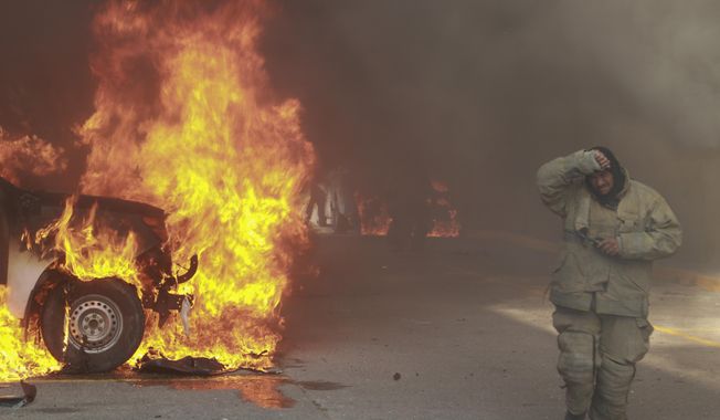 A truck burns after it was set fire by rural teachers&#x27; college students protesting the previous month&#x27;s shooting of one of their classmates during a confrontation with police, as firefighters work to control the blazes outside the municipal government palace in Chilpancingo, Mexico, Monday, April 8, 2024. (AP Photo/Alejandrino Gonzalez)