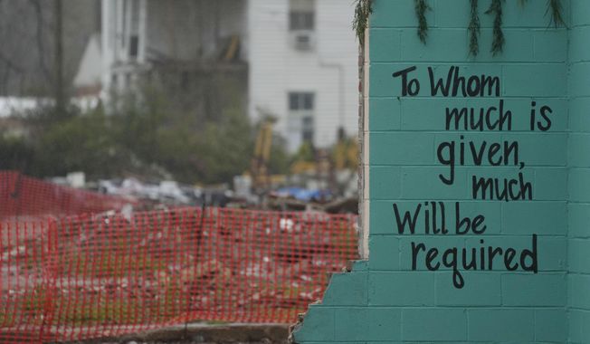 A painted bible verse is seen inside of what is left of a building on March 22, 2024, that was destroyed by a deadly tornado in March 2023 in Rolling Fork, Miss. One year after the deadly tornado struck, buildings throughout town remain boarded up, and the remnants of destroyed properties dot the landscape. The tornado killed 14 residents and reduced the town to rubble as it charted a merciless path across one of the country’s poorest regions. (AP Photo/Rogelio V. Solis)