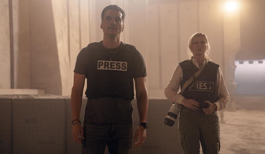 This image released by A24 shows Wagner Moura, left, and Kirsten Dunst in a scene from &quot;Civil War.&quot; (Murray Close/A24 via AP)