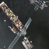 This satellite image provided by Maxar shows the bow of the container ship Dali remains stuck underneath sections of the fallen Francis Scott Key Bridge, while salvage crews and barges with cranes continue removing some of the bridge debris and hundreds of shipping containers still onboard the vessel, in Baltimore, Monday, April 8, 2024. (Satellite image ©2024 Maxar Technologies via AP)