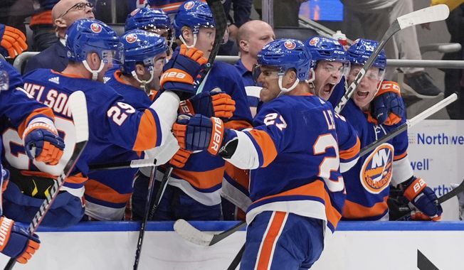 New York Islanders&#x27; Anders Lee (27) celebrates with teammates after scoring an empty net goal during the third period of an NHL hockey game against the New York Rangers Tuesday, April 9, 2024, in Elmont, N.Y. (AP Photo/Frank Franklin II)