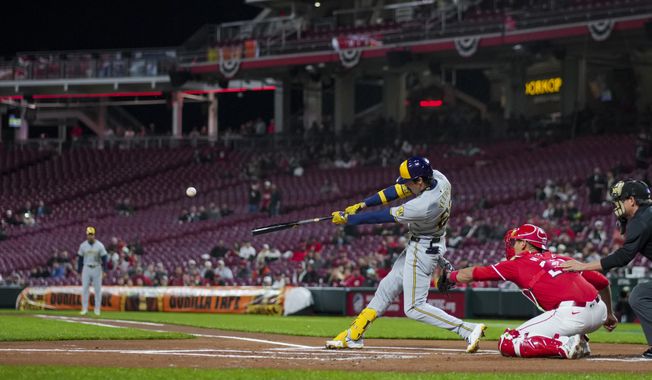Milwaukee Brewers&#x27; Christian Yelich hits a two-run home run during the first inning of a baseball game against the Cincinnati Reds in Cincinnati, Wednesday, April 10, 2024. (AP Photo/Aaron Doster)
