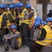 Workers wait for transport outside a construction site in Beijing, Tuesday, April 9, 2024. China&#x27;s Finance Ministry has denounced a report by Fitch Ratings that kept its sovereign debt rated at A+ but downgraded its outlook to negative, saying in a statement that China&#x27;s deficit is at a moderate and reasonable level and risks are under control. (AP Photo/Ng Han Guan)