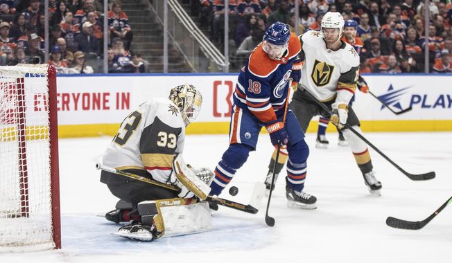 Vegas Golden Knights goalie Adin Hill (33) makes the save on Edmonton Oilers&#x27; Zach Hyman (18) during the second period of an NHL hockey game in Edmonton, Alberta on Wednesday April 10, 2024.(Jason Franson/The Canadian Press via AP)