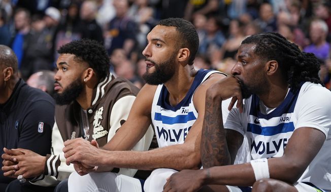 Minnesota Timberwolves centers Karl-Anthony Towns, Rudy Gobert and Naz Reid, from left, watch from the bench late in the second half of the team&#x27;s NBA basketball game against the Denver Nuggets on Wednesday, April 10, 2024, in Denver. (AP Photo/David Zalubowski)