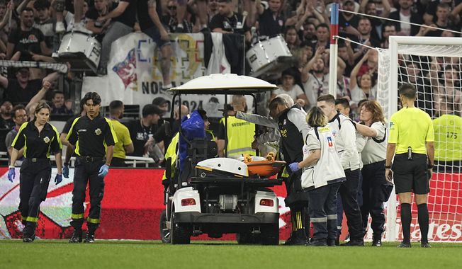 Lyon&#x27;s Alexandre Lacazette is carried injured out of the pitch by medical staff during a French League One soccer match between Lyon and Brest at the Groupama stadium, outside Lyon, France, Sunday, April 14, 2024. (AP Photo/Laurent Cipriani)