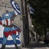 A man walks past a mural depicting the U.S. president Joe Biden as a superhero defending Israel on a street in Tel Aviv, Israel, Sunday, April 14, 2024. Israel on Sunday hailed its successful air defenses in the face of an unprecedented attack by Iran, saying it and its allies thwarted 99% of the more than 300 drones and missiles launched toward its territory. But regional tensions remain high, amid fears of further escalation in the event of a possible Israeli counter-strike. (AP Photo/Leo Correa)