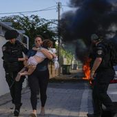 Israeli police officers evacuate a woman and a child from a site hit by a rocket fired from the Gaza Strip, in Ashkelon, southern Israel, Saturday, Oct. 7, 2023. Thousands of Hamas-led militants storm across the border into Israel, killing 1,200 people, mostly civilians, and taking roughly 250 captive, according to Israeli authorities. (AP Photo/Tsafrir Abayov) **FILE**