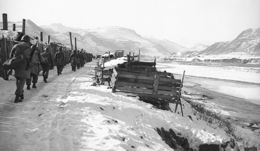 Americans of the Seventh Division's 17th Regimental Combat team march along the North Korean bank of the Yalu River, right, on Nov. 25, 1950, after reaching the border town of Hyesanjin to climax their daring drive north. Snow-covered hills of Manchuria loom over river at right. Gene Herrick, a retired Associated Press photographer who covered the Korean War and is known for his iconic images of Martin Luther King Jr., Rosa Parks and the civil rights movement, died Friday, April 12, 2024 at a nursing home in Rich Creek, Virginia. He was 97. (AP Photo/Gene Herrick, File)
