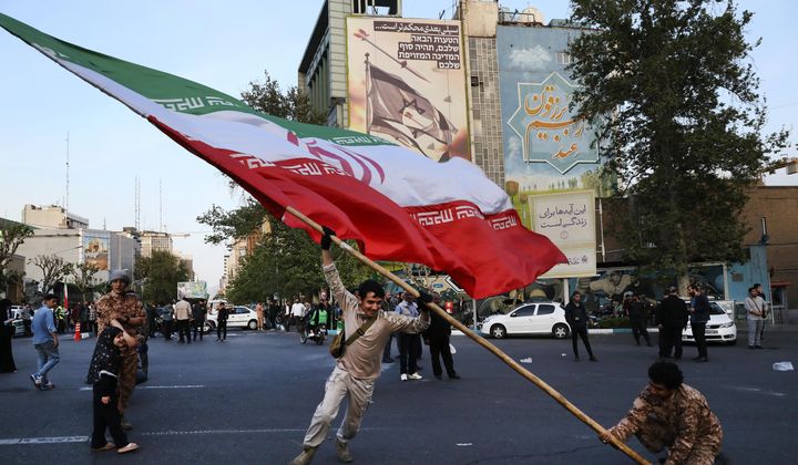 Demonstrators wave a huge Iranian flag in their anti-Israeli gathering in front of an anti-Israeli banner on the wall of a building at the Felestin (Palestine) Square in Tehran, Iran, Monday, April 15, 2024. World leaders are urging Israel not to retaliate after Iran launched an attack involving hundreds of drones, ballistic missiles and cruise missiles. The sign on the banner reads in Hebrew: &quot;Your next mistake will be the end of your fake country.&quot; And the sign in Farsi reads: &quot;The next slap will be harder.&quot; (AP Photo/Vahid Salemi) **FILE**