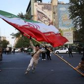Demonstrators wave a huge Iranian flag in their anti-Israeli gathering in front of an anti-Israeli banner on the wall of a building at the Felestin (Palestine) Square in Tehran, Iran, Monday, April 15, 2024. World leaders are urging Israel not to retaliate after Iran launched an attack involving hundreds of drones, ballistic missiles and cruise missiles. The sign on the banner reads in Hebrew: &quot;Your next mistake will be the end of your fake country.&quot; And the sign in Farsi reads: &quot;The next slap will be harder.&quot; (AP Photo/Vahid Salemi)