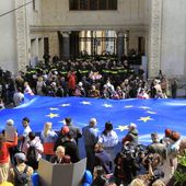 Protestors with a giant EU flag gather outside the parliament building in Tbilisi, Georgia, on Monday, April 15, 2024 to protest against the &quot;the Russian law&quot; as it is similar to a law that Russia uses to stigmatize independent news media and organizations seen as being at odds with the Kremlin. The governing party in the country of Georgia has submitted to parliament a draft law calling for media and non-commercial organizations to register as being under foreign influence if they receive more than 20% of their budget from abroad. (AP Photo/Shakh Aivazov)