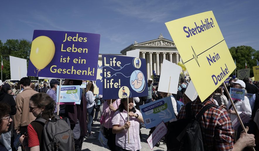 Participants in the &#x27;March for Life&#x27; rally stand with banners reading &#x27;Every life is a gift&#x27;, &#x27;Life is life&#x27; and &#x27;Euthanasia no thanks&#x27; in Munich, Germany, Saturday, April 13, 2024. An independent experts commission has recommended that abortion in Germany should no longer fall under the country’s penal code and be made legal during the first 12 weeks of pregnancy. Currently, abortion is considered illegal in Germany, but not punishable if a woman undergoes mandatory counseling and a three-day wait period before she has the procedure. (Uwe Lein/dpa via AP)