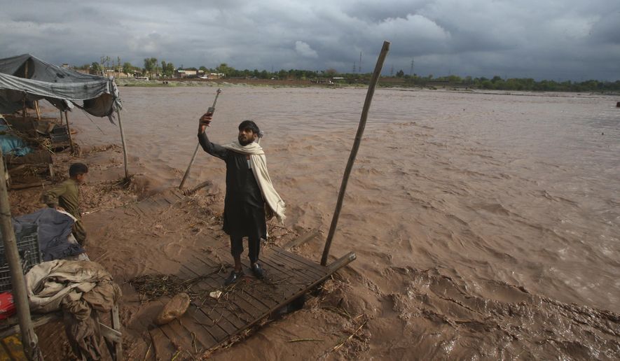 A man takes a selfie on the bank of a stream, which is overflowing following heavy rains, on the outskirts of Peshawar, Pakistan, Monday, April 15, 2024. Lightnings and heavy rains killed dozens of people, mostly farmers, across Pakistan in the past three days, officials said Monday, as authorities declared a state of emergency in the country&#x27;s southwest following an overnight rainfall to avoid any further casualties and damages. (AP Photo/Muhammad Sajjad)