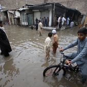 Youngsters wade through a flooded street caused by heavy rain in Peshawar, Pakistan, Monday, April 15, 2024. Lightening and heavy rains killed dozens of people, mostly farmers, across Pakistan in the past three days, officials said Monday, as authorities declared a state of emergency in the country&#x27;s southwest following an overnight rainfall to avoid any further casualties and damages. (AP Photo/Muhammad Sajjad)