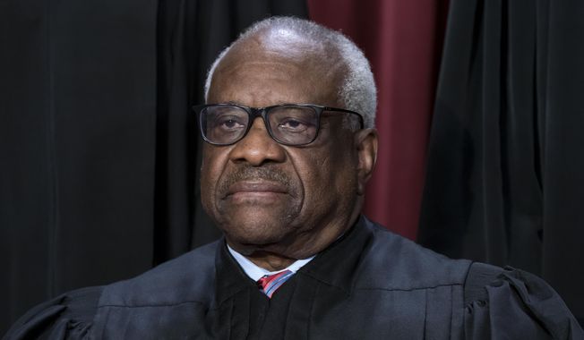 Associate Justice Clarence Thomas joins other members of the Supreme Court as they pose for a new group portrait, at the Supreme Court building in Washington, Oct. 7, 2022. Thomas is absent from the court on Monday with no explanation. The 75-year-old Thomas also is not participating remotely in arguments, as justices sometimes do when they are ill or otherwise can’t be there in person. Chief Justice John Roberts announced Thomas’ absence, saying that his colleague would still participate in the day’s cases, based on the briefs and the transcripts of the arguments. (AP Photo/J. Scott Applewhite, File)