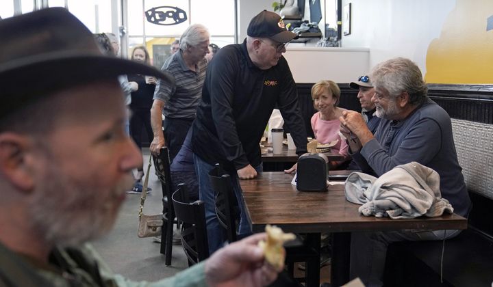 Former Maryland Gov. Larry Hogan, center, talks with patrons of DePaola&#x27;s Bagel and Brunch in Stevensville, Md., Friday, April 12, 2024, as he campaigns for the U.S. Senate. (AP Photo/Susan Walsh)
