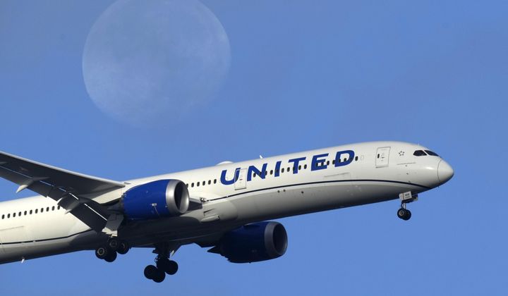 A United Airlines Boeing 787 approaches for landing in Lisbon, Sept. 2, 2023, with the setting moon in the background. United Airlines reports their earnings on Tuesday, april 16, 2024. (AP Photo/Armando Franca, File)