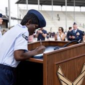 Airman 1st Class D&#x27;elbrah Assamoi, from Cote D&#x27;Ivoire, signs her U.S. certificate of citizenship after the Basic Military Training Coin Ceremony at Joint Base San Antonio-Lackland, in San Antonio, April 26, 2023. The Army and Air Force say they are on track to meet their recruiting goals in 2024, reversing previous shortfalls using a swath of new programs and policy changes. But the Navy, while improving, expects once again to fall short. (Vanessa R. Adame/U.S. Air Force via AP, File)