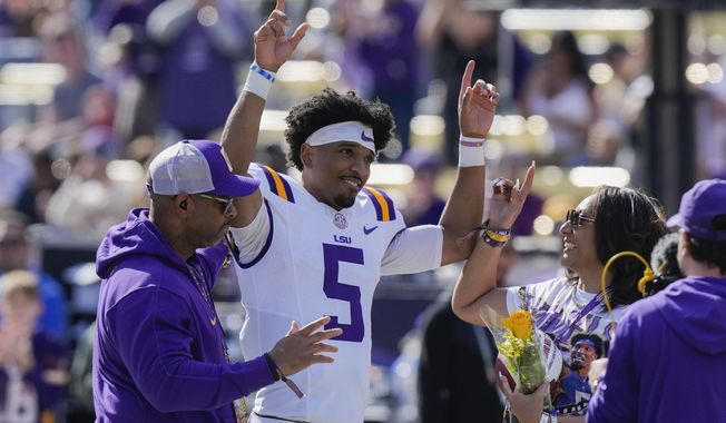 FILE - LSU quarterback Jayden Daniels (5) celebrates with his parents on senior day, for his final home game, before an NCAA college football game against Texas A&amp;M in Baton Rouge, La., Saturday, Nov. 25, 2023. Daniels is a possible first round pick in the NFL Draft.(AP Photo/Gerald Herbert, File)
