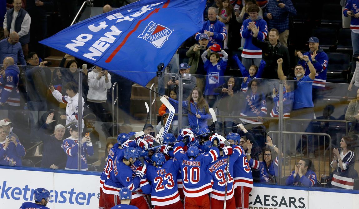 The New York Rangers and fans celebrate a shootout victory over the New York Islanders in an NHL hockey game April 13, 2024, in New York. As the NHL playoffs begins this weekend, ushering in the most exciting hockey of the year, business is booming and the league has bounced back in a big way from the pandemic. (AP Photo/John Munson, File) **FILE**