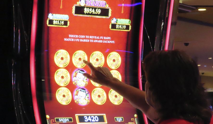 A gambler touches the screen of a slot machine at Harrah&#x27;s casino in Atlantic City N.J., Sept. 29, 2023. Figures released, Tuesday, April 16, 2024, show Atlantic City&#x27;s casinos, their online partners and horse tracks that take sports bets won over $526 million in March, a month in which New Jersey&#x27;s internet gambling market set yet another monthly record at $197 million. (AP Photo/Wayne Parry)