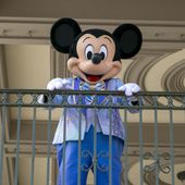 An actor dressed as Mickey Mouse greets visitors at the entrance to Magic Kingdom Park at Walt Disney World Resort, April 18, 2022, in Lake Buena Vista, Fla. Winnie the Pooh and Mickey Mouse have recently entered the public domain, making it possible for artists to use them freely. (AP Photo/Ted Shaffrey, File)
