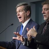 North Carolina Gov. Roy Cooper, left, answers questions at a news conference in which he declared a state of emergency for North Carolina, March 10, 2020. Cooper’s decisions during the COVID-19 pandemic that resulted in bars being shuttered or severely restricted while restaurants that served alcohol could reopen were &quot;illogical&quot; and don&#x27;t appear justified by evidence, a state appeals court ruled Tuesday, April 16, 2024. (Julia Wall/The News &amp; Observer via AP, File)