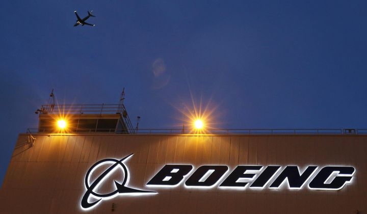 An airplane flies over a sign on Boeing&#x27;s 737 delivery center, Oct. 19, 2015, at Boeing Field in Seattle. (AP Photo/Ted S. Warren, File)