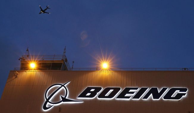 An airplane flies over a sign on Boeing&#x27;s 737 delivery center, Oct. 19, 2015, at Boeing Field in Seattle. Boeing will be in the spotlight during back-to-back hearings Wednesday, April 17, 2024, as Congress examines allegations of major safety failures at the embattled aircraft manufacturer. (AP Photo/Ted S. Warren, File)