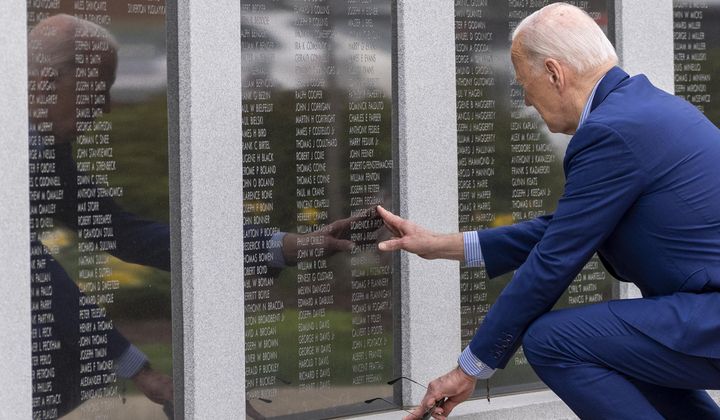 President Joe Biden reaches to touch the name of his uncle Ambrose J. Finnegan, Jr., on a wall at a Scranton war memorial, Wednesday, April 17, 2024, in Scranton, Pa. His uncle died in WWII. (AP Photo/Alex Brandon)