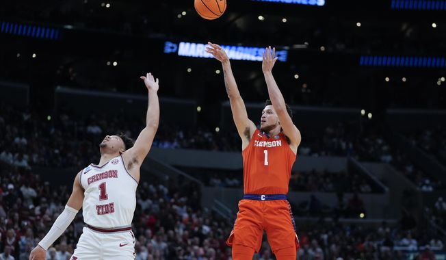 Clemson guard Chase Hunter, right, shoots over Alabama guard Mark Sears (1) during the second half of an Elite 8 college basketball game in the NCAA tournament Saturday, March 30, 2024, in Los Angeles. (AP Photo/Ryan Sun)