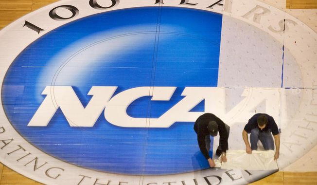 Wachovia Center operations manager Jim McDonald, left, and carpenter foreman Tim Allen remove the protective film covering the NCAA logo at mid-court on the center&#x27;s basketball court, Wednesday, March 15, 2006, in Philadelphia. NCAA athletes will be immediately eligible to play no matter how many times they transfer — as long as they meet academic requirements — after the association fast-tracked legislation Wednesday, April 17, 2024, to fall in line with a recent court order. (Ed Hille/The Philadelphia Inquirer via AP, FIie)