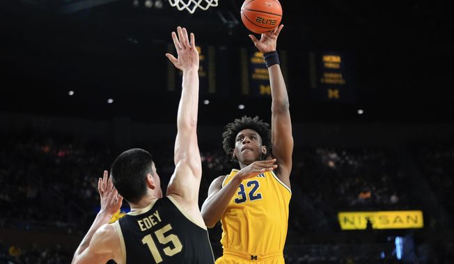 Michigan forward Tarris Reed Jr. (32) shoots against Purdue center Zach Edey (15) in the second half of an NCAA college basketball game in Ann Arbor, Mich., Sunday, Feb. 25, 2024. Former Michigan center Tarris Reed Jr. announced Wednesday, April 17, 2024, that he is transferring to UConn. (AP Photo/Paul Sancya, File)