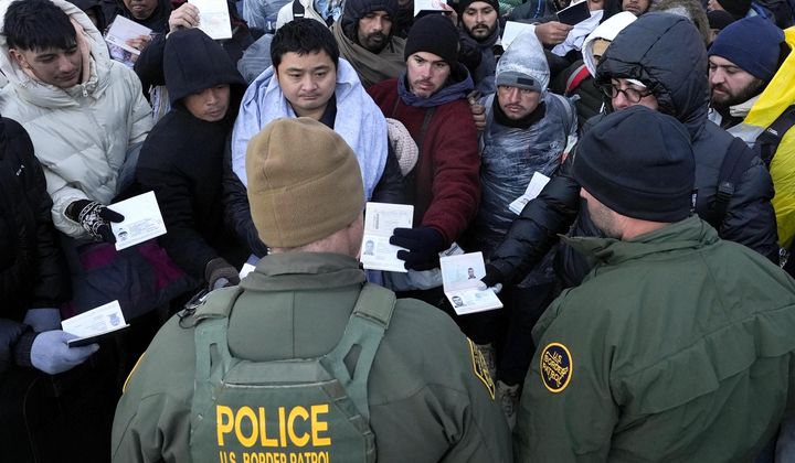 Border Patrol agents ask asylum-seeking migrants to line up in a makeshift, mountainous campsite after the group crossed the border with Mexico,Feb. 2, 2024, near Jacumba Hot Springs, Calif. (AP Photo/Gregory Bull, File)