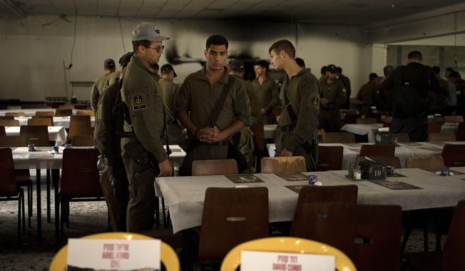Israeli soldiers look at chairs for hostages held in Gaza at a Passover Seder table on Thursday, April 11, 2024, at the communal dining hall at Kibbutz Nir Oz in southern Israel, where a quarter of all residents were killed or captured by Hamas on Oct. 7, 2023. For many Jews, no matter how observant, Passover is a time to unite with family to eat and drink around what&#x27;s known as a Seder table, remembering how the Jews persevered through harsh times. But this year, when Passover begins on Monday, many families are torn on how to celebrate, or if it&#x27;s worth acknowledging at all. (AP Photo/Maya Alleruzzo)