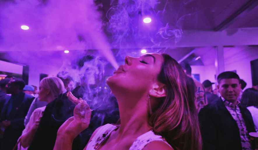FILE - A guest takes a puff from a marijuana cigarette at the Sensi Magazine party celebrating the 420 holiday in the Bel Air section of Los Angeles, April 20, 2019. Marijuana advocates are gearing up for Saturday, April 20, 2024. Known as 4/20, marijuana&#x27;s high holiday is marked by large crowds gathering in parks, at festivals and on college campuses to smoke together. This year, activists can reflect on how far the movement has come. (AP Photo/Richard Vogel, File)