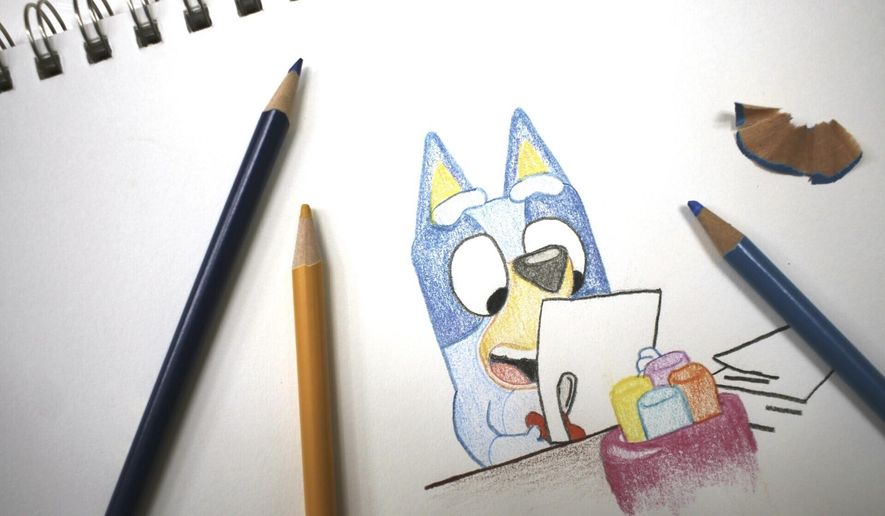 Colored pencils sit around a drawing of "Bluey" the Australian kids' television program character on a sketch pad Friday, April 19, 2024, in Phoenix, Ariz. (AP Photo/Cheyanne Mumphrey)