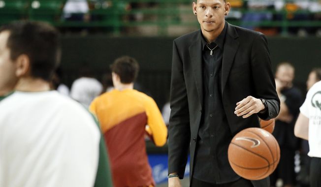 Baylor student assistant Isaiah Austin prepares to toss a ball in as players run through drills before an NCAA college basketball game against Iowa State in Waco, Texas, Jan. 14, 2015. Former Baylor basketball player Isaiah Austin, whose NBA dreams were thwarted after being diagnosed with Marfan syndrome, was hired Friday, April 19, 2024, as an assistant coach at Florida Atlantic. Austin spent the past two years working for the NBA, and will now coach for the first time. (AP Photo/Tony Gutierrez, File)