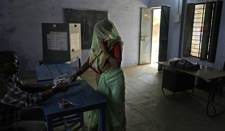 A woman shows voting slip before she casts her vote during the first round of voting of India&#x27;s national election in Behror, Rajasthan state, India, Friday, April 19, 2024. Nearly 970 million voters will elect 543 members for the lower house of Parliament for five years, during staggered elections that will run until June 1. (AP Photo/Manish Swarup)